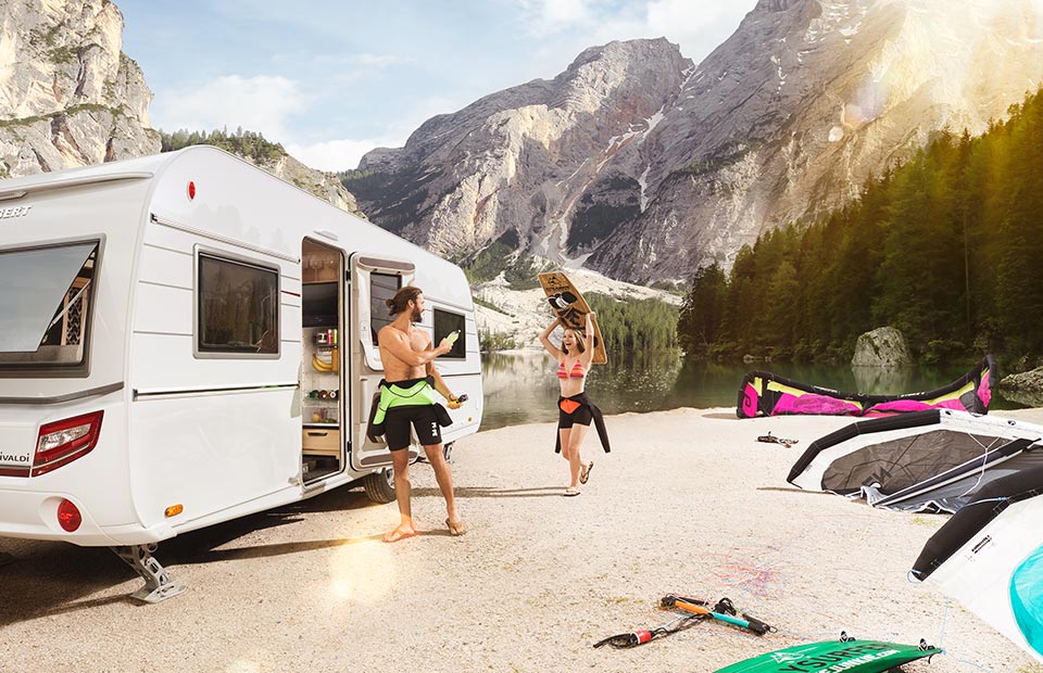 Wohnwagen mit Paar am See, Süddeutschland, Bayern, Allgäu